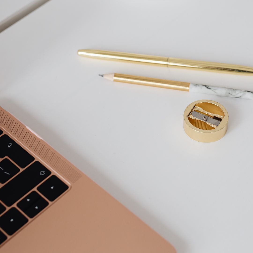 Gold pen and laptop